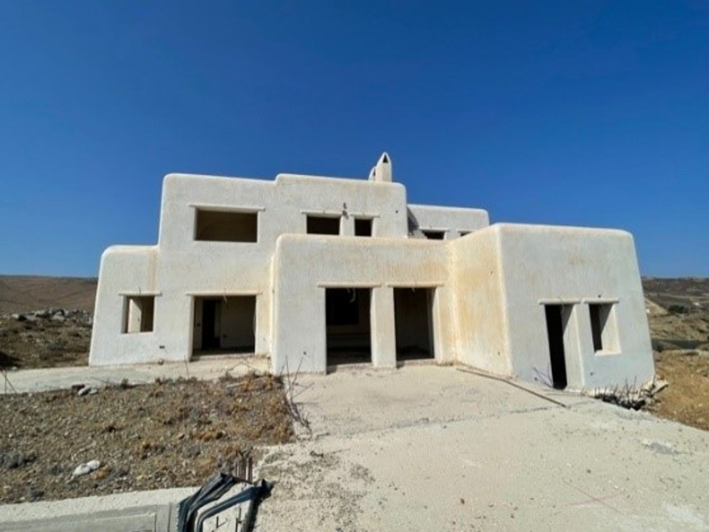 Foto de um complexo com várias vilas inacabadas em Mykonos que a EOS está reestruturando para atender aos padrões sustentáveis.