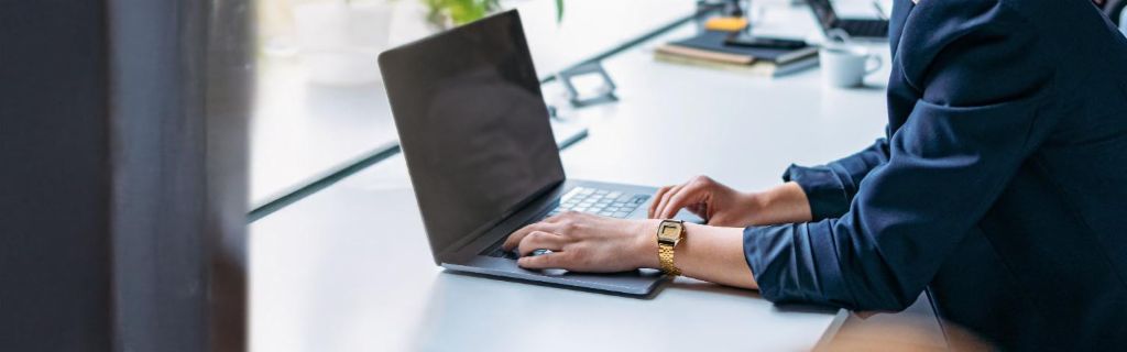 Jovem mulher a trabalhar num portátil num escritório moderno.