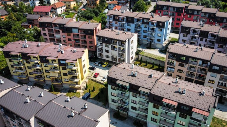 NPL garantidos por imóveis: vista aérea de um complexo residencial vibrante com edifícios coloridos rodeados de áreas verdes na Bósnia e Herzegovina