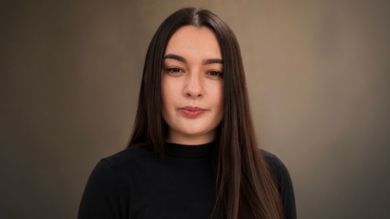 Daniela Moaca, Senior Manager IT na EOS Romania, fotografia de retrato com uma camisola de gola alta escura.