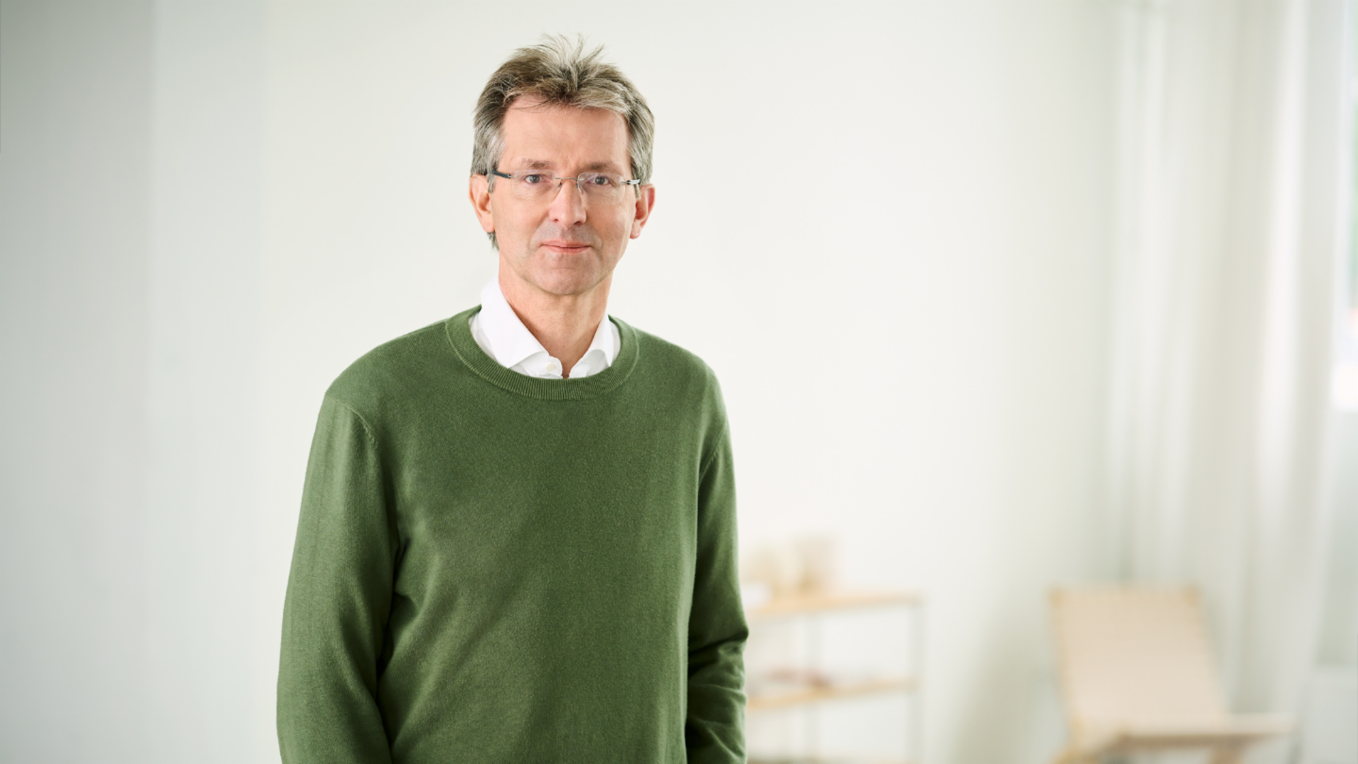 Justus Hecking-Veltman, CFO, está numa sala iluminada e veste um pulôver verde com uma camisa branca.