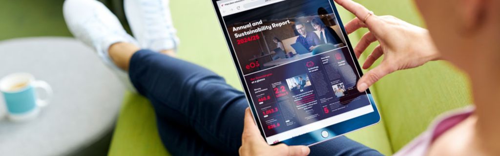 Pessoa em sofá verde visualizando o Relatório Anual e de Sustentabilidade da EOS 2024/25 em um tablet