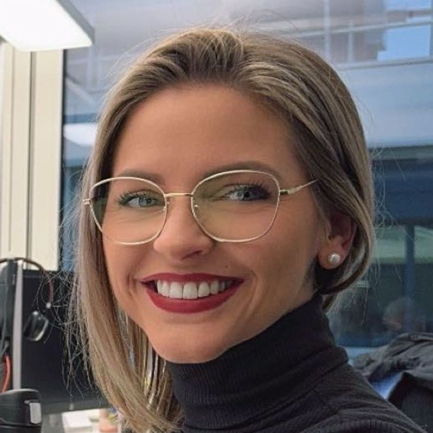 Genny Bollinger, especialista em reestruturação de dívidas da EOS na Suíça, está sentada à sua secretária com uma camisola cinzenta de gola alta e sorri para a câmara.